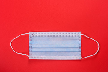Medical mask on a colored background, a means of protection against coronovirus and epidemic