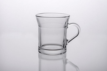 Empty white coffee cup on a light glass background