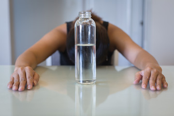 Hungry frustrated woman trying to lose weight, with a glass of water. Intermittent fasting.