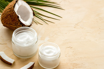 Obraz na płótnie Canvas Face care. Coconut cream in glass jar on beige background copy space