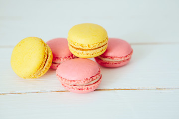 Sweet colorful French macaroon cookies dessert on white wooden table