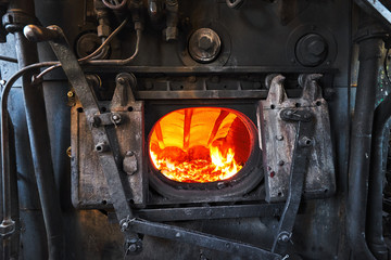 A steam engine train boiler with a burning fire