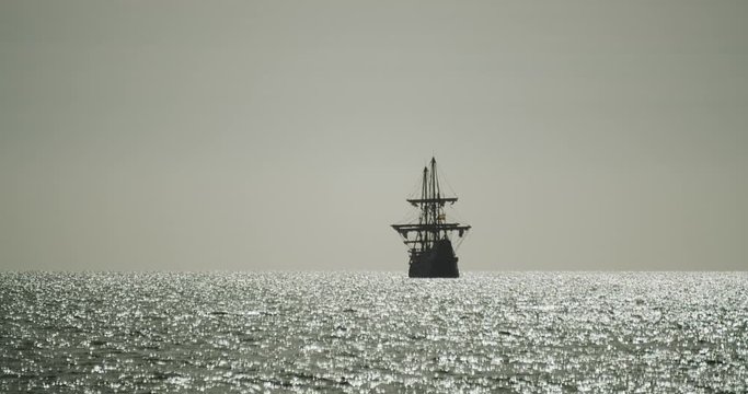 Christopher Columbus caravel replica ship sails away in the distance while birds fly around