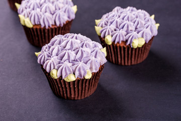 Delicate chocolate cupcakes close-up on a dark table with a napkin.