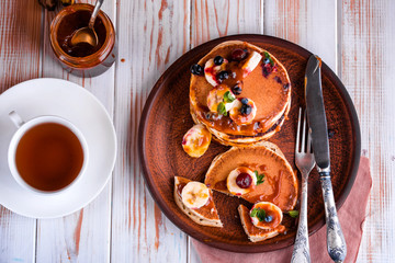 Delicious and lush pancakes with fresh fruits and berries, poured with salted caramel.