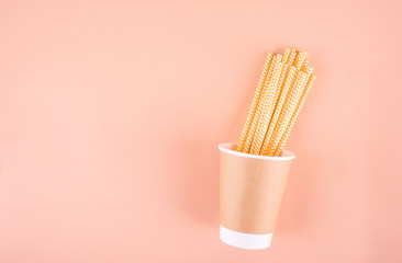 Paper glass with drinking tubes. Eco utensils on a light background. Zero waste.