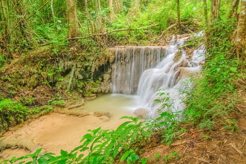 view of silky waterfall flowing around with green forest background, Pu Kaeng Waterfall, Doi Luang National Park, Chiang Rai, Northern of Thailand.