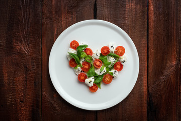 Ingredients for Caprese salad in the form of a heart. Symbol of love for Italian food