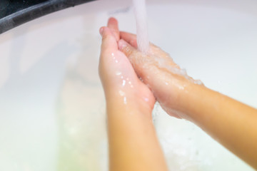 Coronavirus and Covid-19 concept.Kid girl washing hands with soap under the faucet with water in bathroom at home.Stop corona virus outbreak.Coronavirus and epidemic virus symptoms.Step by Step.