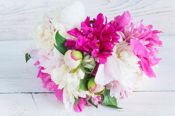 Bouquet of purple, pink and white peonies on white paint wooden background. Close up