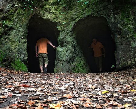 Multiple Image Of Man Walking At Cave Entrance