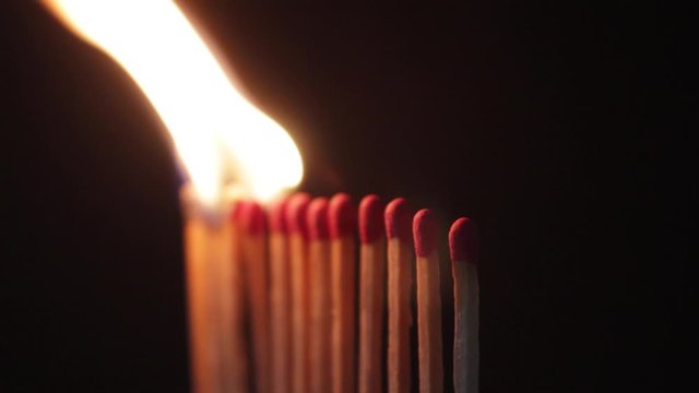 burning matches contagion, match igniting in domino effect. line of light matches on black ground