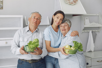 Family in a kitchen. Grandparents with granddaughter. Family made a salad