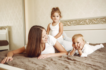 Fototapeta na wymiar Cute family in a room. Lady in a white shirt. Mother with cute children