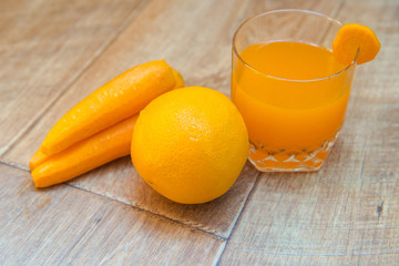 Carrot juice. carrot and orange juice. Healthy food, healthy drink. Orange juice in a glass and next peeled carrots. healthy eating for breakfast. Wood background