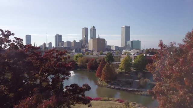 Aerial drone footage of Tulsa breaking through the trees in Autumn.