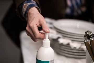 Hand using disinfection pump in a restaurant