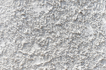 White cement wall with ragged and dirty surface texture. The old and broken rough white concrete wall background.