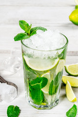 Mojito drink in a glass glass with ice and lime slices