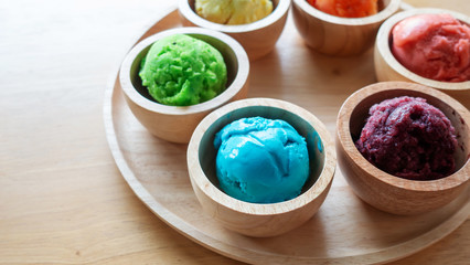 Colorful ice cream on a wooden table.
