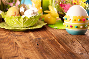 Obraz na płótnie Canvas Happy Easter background. Bouquet of spring flowers. Easter decorations and Easter eggs in basket on rustic wooden table.
