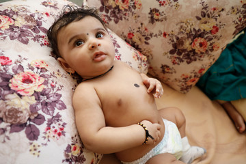 Cute Indian little boy playing on bed 