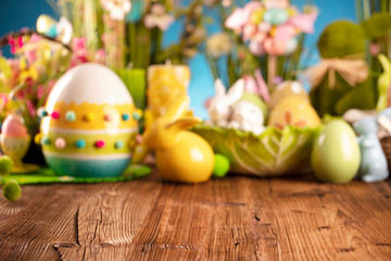 Happy Easter background. Bouquet of spring flowers. Easter decorations and Easter eggs in basket on rustic wooden table.