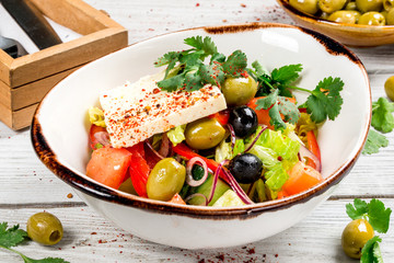 Salad with feta cheese, olives, fresh tomato and herbs