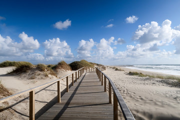 Wooden pedestrian bridge among the sandy beaches of the Atlantic ocean in Costa Nova