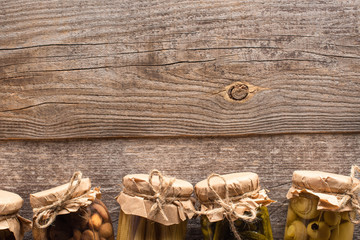 top view of homemade pickles in jars on wooden table with copy space