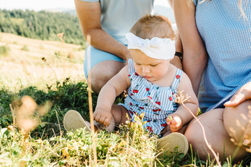 Portrait of happy family. Mom, dad hugging daughter at nature. Young couple spending time together...