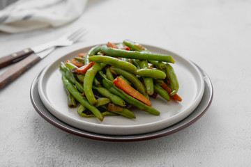 Healthy or vegan food. Cooked green string beans and carrots. Healthy salad of green beans and carrots close up.