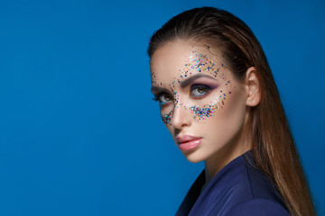 Beauty portrait of a beautiful woman with creative evening make-up with sparkles in the form of a...