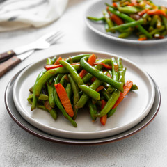 Vegan food. Cooked green string beans and carrots. Healthy salad of green beans and carrots close up. Square image.
