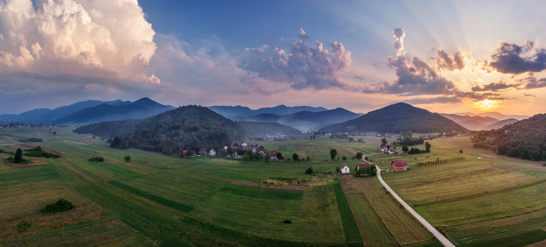Beautiful sunset in mountains in Croatia. Bird's eye view panorama of amazing sky and the red sun lights shooting clouds over valley. © volff