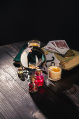 KYIV, UKRAINE - JANUARY 9, 2020: selective focus of crystal ball, candles and occult objects on wooden and black background