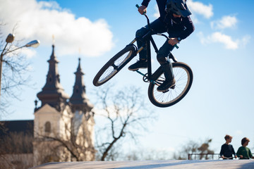 Young man doing tricks on a BMX bike. BMX freestyle against the backdrop of urban landscape. Extreme sports is very popular among youth.