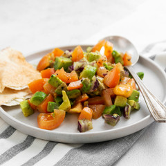 Avocado salad with tomatoes and red onions, flat lay vegan salad. Healthy vegan food. Square image.