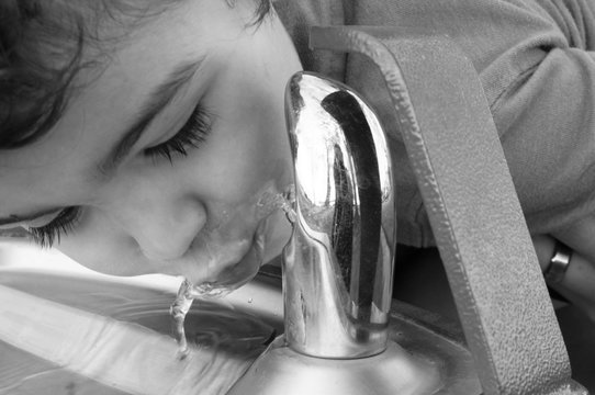 Close-up Of Girl Drinking Water From Faucet