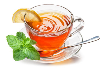 Glass cup with black tea, a slice of lemon and mint leaves isolated on a white background. © volff