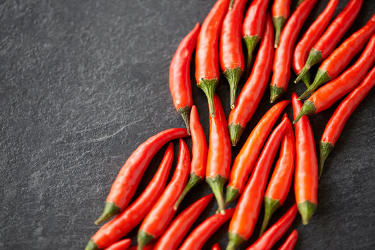 cooking, food and culinary concept - red chili or cayenne pepper on slate stone surface