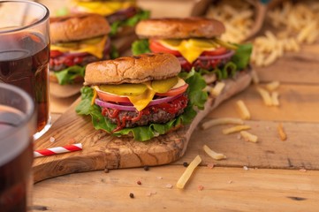 Juicy homemade french fries and soda burgers. Wooden texture with space for design. Delicious and fast food.