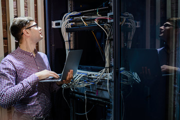 Photo with relfections  in the server room a technician/ It engineer/