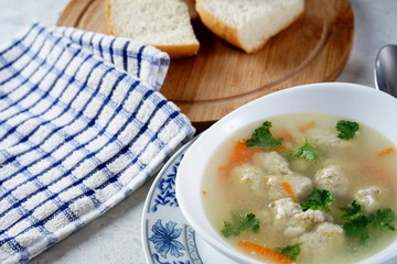 Soup with meatballs on a white plate. Selective focus