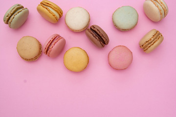 Top view colorful abstract pink background with french macaroons cookies, copy space. Feminine or beauty background.