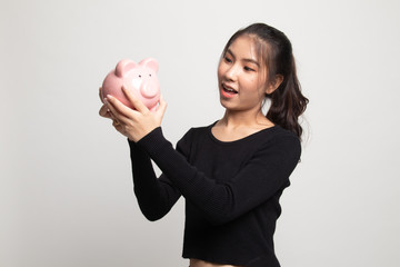 Young Asian woman with a pig coin bank.