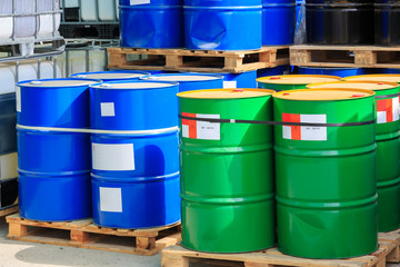 Big green and blue barrels on wooden pallets