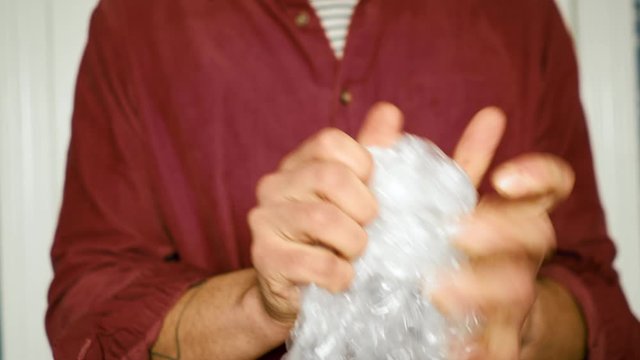Young man popping bubble wrap