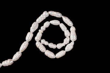 River pearl beads on a black background isolated