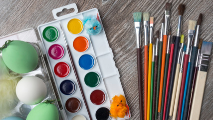 Naklejka premium easter eggs and colorful paints and brushes, bunny